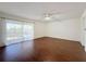 This bedroom features hardwood floors, white walls, and sliding glass doors to a balcony at 9201 Tudor Dr # C212, Tampa, FL 33615