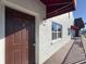 Exterior view of the unit featuring a red awning, a brown front door, and a small window at 9201 Tudor Dr # C212, Tampa, FL 33615