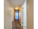 Neutral hallway showcasing the flooring and wall paint, leading to an open room with lots of light at 9201 Tudor Dr # C212, Tampa, FL 33615