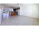 Open-concept living area with tiled floors leads to a kitchen featuring an island and modern appliances at 9201 Tudor Dr # C212, Tampa, FL 33615