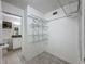 Walk-in closet featuring wire shelving and tiled floor that opens to a bathroom at 9201 Tudor Dr # C212, Tampa, FL 33615