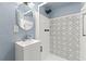 Stylized bathroom showcasing new shower design and fixtures, with unique shower tiles at 9241 Cochise Ln, Port Richey, FL 34668