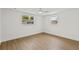 Light and airy bedroom featuring wood floors and dual windows at 9241 Cochise Ln, Port Richey, FL 34668