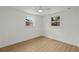 Bright bedroom with wood floors and natural light from two windows at 9241 Cochise Ln, Port Richey, FL 34668