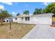A lovely single story home with a light colored exterior, garage, driveway and landscaped front yard at 9241 Cochise Ln, Port Richey, FL 34668
