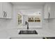 Bright kitchen sink with modern fixtures, white subway tile and backyard views at 9241 Cochise Ln, Port Richey, FL 34668