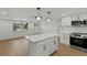 Bright, open kitchen with white cabinets, center island and stainless steel appliances at 9241 Cochise Ln, Port Richey, FL 34668