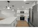 Modern kitchen with white cabinetry, stainless steel appliances and a large center island at 9241 Cochise Ln, Port Richey, FL 34668