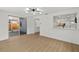 Bright living room with sliding glass doors, light hardwood floors, and modern lighting fixture at 9241 Cochise Ln, Port Richey, FL 34668