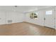 A well-lit, open living space with a large window, hardwood floors, and white colored walls at 9241 Cochise Ln, Port Richey, FL 34668