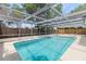 Clean, screened-in swimming pool with a white concrete deck at 9241 Cochise Ln, Port Richey, FL 34668