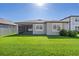 Beautiful backyard view featuring lush green lawn and a glimpse of the home's rear exterior at 9271 Rally Spring Loop, Wesley Chapel, FL 33545