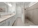 Bright bathroom showcasing double vanity and walk-in shower with tiled walls at 9271 Rally Spring Loop, Wesley Chapel, FL 33545