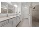 Spacious bathroom boasting a double vanity, well-lit mirror, and tiled walk-in shower at 9271 Rally Spring Loop, Wesley Chapel, FL 33545