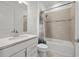 Well-lit bathroom featuring a vanity, toilet, and shower-tub with curtain and neutral tile at 9271 Rally Spring Loop, Wesley Chapel, FL 33545
