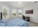 Bedroom with a blue bed and windows for natural light and backyard views at 9271 Rally Spring Loop, Wesley Chapel, FL 33545