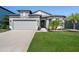 Charming single-Gathering home with well-manicured lawn, a gray stucco finish, and a spacious two-car garage at 9271 Rally Spring Loop, Wesley Chapel, FL 33545
