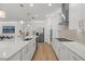 Elegant kitchen features stainless steel appliances, quartz countertops, and center island with sink at 9271 Rally Spring Loop, Wesley Chapel, FL 33545