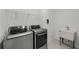 Well-equipped laundry room with modern washer, dryer and a practical utility sink at 9271 Rally Spring Loop, Wesley Chapel, FL 33545