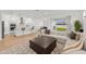 Open-concept living area with modern kitchen island and comfortable sectional sofa at 9271 Rally Spring Loop, Wesley Chapel, FL 33545