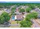 Aerial view shows a home with a screened-in pool and lush landscaping in a suburban neighborhood at 1017 Cameo Crest Ln, Valrico, FL 33596