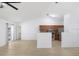 Open living space with new flooring, ceiling fan, and a partial view of kitchen at 1017 Cameo Crest Ln, Valrico, FL 33596