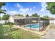 Backyard featuring a screened-in pool and patio area, surrounded by a well-maintained lawn and landscaping at 1017 Cameo Crest Ln, Valrico, FL 33596