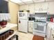 Bright kitchen with white appliances and plenty of counter space, creating a functional workspace at 102 Cambridge Trl # 230, Sun City Center, FL 33573