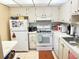 Compact kitchen featuring white cabinets and appliances, maximizing space and functionality at 102 Cambridge Trl # 230, Sun City Center, FL 33573