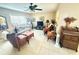 Cozy living room features a ceiling fan, comfortable seating, and lots of natural light at 102 Cambridge Trl # 230, Sun City Center, FL 33573