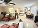Bright living room with tile floors, ceiling fan, and views of kitchen and dining area at 102 Cambridge Trl # 230, Sun City Center, FL 33573
