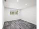 Bright bedroom with gray wood floors, recessed lighting, and a window for natural light at 1119 Eau Claire Cir, Tampa, FL 33619