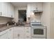 Bright kitchen features white cabinets, tile flooring and modern appliances at 11485 Oakhurst Rd # 200-101, Largo, FL 33774