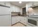 Bright kitchen features white cabinets, tile flooring and modern appliances at 11485 Oakhurst Rd # 200-101, Largo, FL 33774