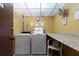 Community laundry room featuring multiple washers, dryers, and a folding station at 11485 Oakhurst Rd # 200-101, Largo, FL 33774