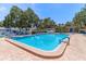 Community pool with lounge chairs, mature shade trees, and plenty of space to relax at 11485 Oakhurst Rd # 200-101, Largo, FL 33774