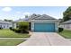 Charming single-story home featuring a vibrant blue garage door and well-manicured landscaping at 11845 Autumn Creek Dr, Riverview, FL 33569
