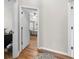Hallway view leading to a bedroom with wood-look flooring and an open door at 11845 Autumn Creek Dr, Riverview, FL 33569
