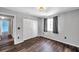 This bedroom has wood floors, closet, and a window with curtains for privacy at 1204 Rinkfield Pl, Brandon, FL 33511