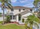 Inviting home exterior featuring a lush lawn, mature palms, and covered entryway at 1204 Rinkfield Pl, Brandon, FL 33511