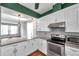 Bright kitchen with stainless steel appliances, granite countertops, and white cabinets at 1204 Rinkfield Pl, Brandon, FL 33511