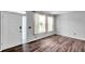Bright, open living room featuring wood laminate flooring and multiple windows for natural light at 1204 Rinkfield Pl, Brandon, FL 33511