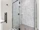 Close up of glass enclosed shower with stylish herringbone tile at 121 E Warren Ave # 4, Tampa, FL 33602