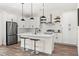 Well-equipped kitchen featuring white cabinetry, a center island, stainless steel appliances, and modern pendant lighting at 121 E Warren Ave # 4, Tampa, FL 33602