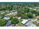 Aerial view of a home with an in-ground pool, mature trees and lush landscaping at 1211 Stony Brook Ln, Dunedin, FL 34698
