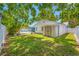 Green grass backyard with a pool, mature trees and a shed at 1211 Stony Brook Ln, Dunedin, FL 34698