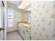Bathroom with dual sink vanity, window, and patterned wallpaper at 1211 Stony Brook Ln, Dunedin, FL 34698