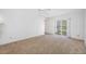 The bedroom offers a sliding door to the outdoors and carpeted flooring at 1211 Stony Brook Ln, Dunedin, FL 34698