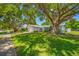 One-story home with lush landscaping, mature shade trees, and a well-maintained front lawn at 1211 Stony Brook Ln, Dunedin, FL 34698