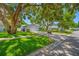 Charming one-story home featuring a lush green lawn and mature trees that provide ample shade at 1211 Stony Brook Ln, Dunedin, FL 34698